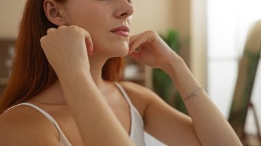 Genç bir kadın sağlık merkezindeki dinlendirici bir anın tadını çıkarıyor. Kendine iyi baktığını ve evin içinde huzurlu bir güzellik gösterisi yaptığını gösteriyor.