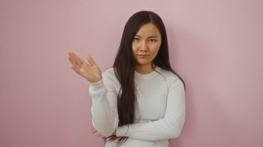 Pembe arka planda kendine güvenen ve kendine güvenen bir ifade sergileyen, güzelliği ve gücü somutlaştıran, güçlendirme, kendine güvenme ve kültürel çeşitlilik temaları için ideal bir kadın..