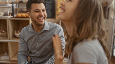 Kadın ve erkek sıcak bir pastanede birlikte gülüyorlar..