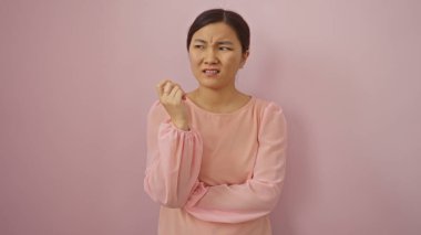 Pembe arka planda pembe bluz giyen bir kadın, şüpheci bir ifade ve düşünceli bir pozla şüpheyi ve düşünmeyi simgeler..