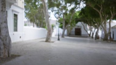 Lanzarote, İspanya 'da ağaçların ve beyaz binaların olduğu, sakinliğin ve doğal güzelliğin vurgulandığı bir açık hava meydanı..