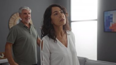 Orta yaşlı bir çift şık bir oturma odasında birlikte olmaktan zevk alıyor. Aynayla birlikte, içeride mutluluk ve bağ gösteriyorlar..