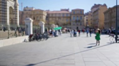 Marsilya 'da yürüyen, Avrupa mimarisini sergileyen insanlarla yeşil elbiseli bir kadının olduğu bulanık bir cadde..