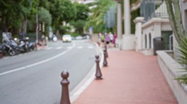 Monako 'da lüks arabaların, bereketli ağaçların ve yayaların, lüks bir ortamda canlı bir atmosfer yarattığı bulanık bir açık hava manzarası..