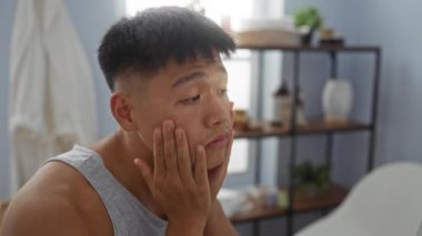 Yakışıklı genç Çinli bir adam sağlık merkezinden cildini kontrol ediyor, içeride yüz bakımına odaklanıyor..