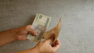 İki eliyle beton bir arka planda Mısır kilolarını tutan ve yelleyen adam.