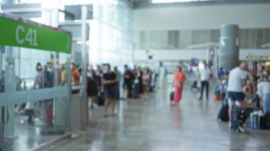 Bulanık gezginler havaalanı terminali C41 kapısında bekliyor. Arka planda insanlar var ve oturma yerleri bulanık.