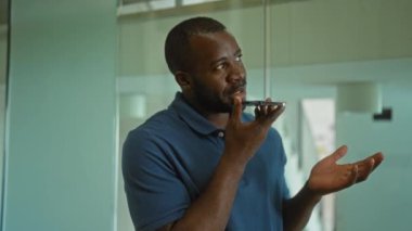 Ofis ortamında akıllı bir telefonla konuşan genç adam, çeşitli düşünceli ve anlamlı pozlarda yakalanmış.