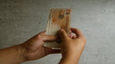 Döviz ve mali işlemleri vurgulayan somut bir arkaplan karşısında İngilizce pound sayan eller