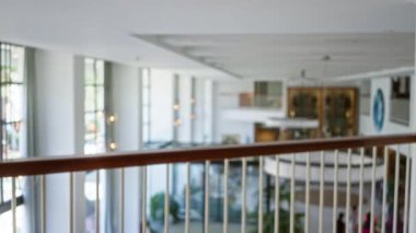Modern dekor ve doğal ışık içeren bir otel lobisinin bulanık görüntüsü büyük camlardan bokeh etkisi ile filtrelenmiş.
