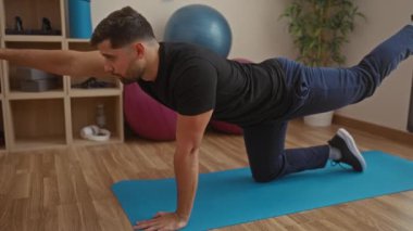 Spor salonunda spor salonunda spor yapan bir adam, spor salonunun içinde yetişkinler için denge ve dayanıklılık eğitimine odaklanmış bir egzersiz öneriyor..