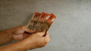 Avustralya parası tutan, somut geçmişi olan, Avustralya dolarlarını sergileyen, finansal veya para birimiyle ilgili konular için mükemmel eller.