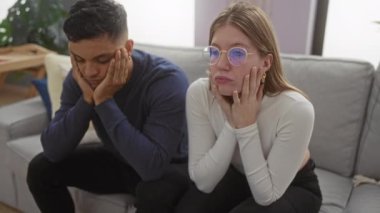 Oturma odasında oturan çift, hoş bir atmosferi olan bir apartman dairesinde düşünceli ve dalgın görünüyor..