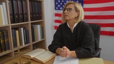 Amerikan bayrağı ve hukuk kitaplarıyla hakim kadın, ABD 'de profesyonel bir yargı kuruluşu tasvir ederek, hukuktaki otorite ve uzmanlığı vurguladı.