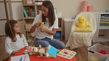 Kadınlar oyun odasında kızları için muz soyarlar, aile ortamında sevgi ve ilgi gösterirler, İspanyol kültürünü yansıtırlar ve çevreyi beslerler..