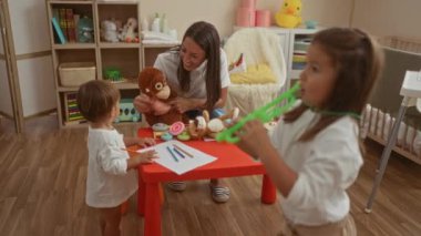 Oyuncak, kitap ve beşikle çevrili, sıcak ve eğitici bir çevreyi besleyen iki çocuk yuvasında iki kadınla meşgul olan bir kadın..