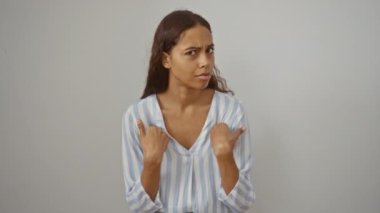 Çizgili gömlekli kadın beyaz bir arka plana işaret ederken komik hareketler yapıyor.