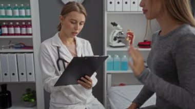 Klinik ofis ortamındaki doktora tıbbi ekipmanlarla danışmanlık yapmak, sağlık ve teşhise odaklanmak, profesyonel etkileşim ve modern sağlık hizmetlerine sahip olmak.