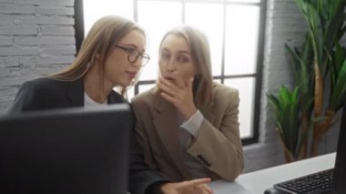 Modern bir ofis ortamında bilgisayarlar ve parlak bir iç mekan ile işbirliği yapan kadınlar