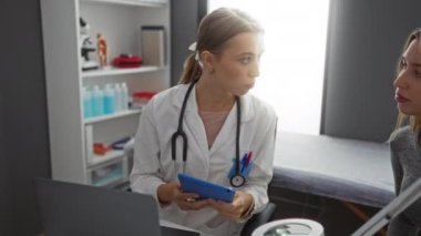 Modern klinik ortamda tablet kullanan, sağlık hizmetlerindeki etkileşim ve teknolojiyi vurgulayan bir doktora danışmanlık.