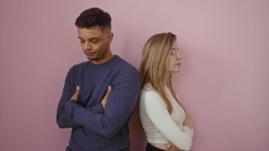 Erkek ve kadın sırt sırta dururlar pembe duvarlara karşı, birbirlerine bakmazlar, ilişkilerdeki gerilimi vurgularlar..