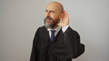 Yargıç cüppeli İspanyol bir adam, sakallı, dinleyen bir jest yapıyor, beyaz bir arka plana karşı izole bir şekilde duruyor..