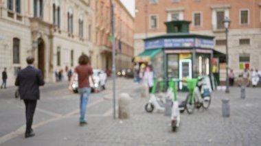 İki adam Roma 'daki kaldırım taşı caddesinde bulanık gece lambaları altında yürür, İtalya' nın canlı şehir ortamının dağılmış bir manzarasını yakalar..