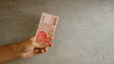 Somut arka plana karşı el ele tutuşan Tayvan Doları tasarısı finans ve döviz temalarını örneklendiriyor.