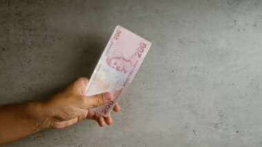 Somut arka plana karşı el ele tutuşan Türk lirası tasarısı, döviz kurunun vurgulanması veya mali işlemler.