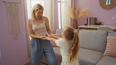 Kadın ve çocuk sıcak bir oturma odasında eğleniyorlar. Evlerinde aile bağlarını vurguluyorlar.