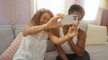 Kadın arkadaşlar kapalı bir salonda selfie çekiyorlar..