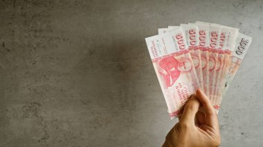 İzlanda Krona 'nın el ele tutuştuğu banknotlar somut bir arka plana karşı, İzlanda' nın para birimini finansal bağlamda vurguluyor..