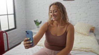 Kadın, yatak odasında doğal ışıkla görüntülü konuşmayı seviyor.