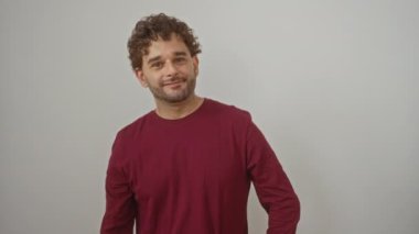 İspanyol asıllı genç adam tişört giyiyor, zafer işareti, gülümseyen parmakları gösteriyor.