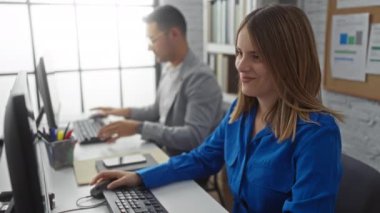 Kapalı alanda işbirliği yapan ofis çalışanları arasında masa başında bilgisayarlarla ve takım çalışması ortamını ön plana çıkaran kağıt işleriyle ilgili işleri tartışan erkek ve kadın da yer alıyor..