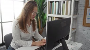 Modern ofiste gözlüklü ve kitaplıklı bir kadın verimlilik ve kapalı bir profesyonel çevrede odaklanma sergiliyor..