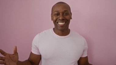 Soyutlanmış pembe arka planda mutlu bir adam. Parlak bir şekilde gülümsüyor, pozitif enerji ve güven gösteriyor. Günlük kıyafetler giyiyor..