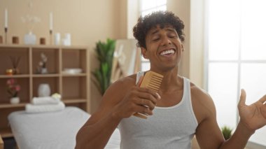 Yakışıklı, İspanyol asıllı genç adam neşeli bir şekilde şarkı söylüyor. Dingin bir sağlıkta mikrofon olarak tarağı kullanıyor. Ve iç güzelliği de davetkar..