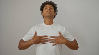 Beyaz gömlekli yakışıklı adam, sakin bir görünüm sergiliyor.