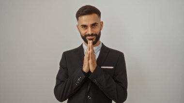 Sakallı ve elleri beyaz arka planda hareket eden genç bir adam.