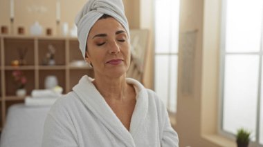 Kafası ve gözleri kapalı, güzellik merkezinin huzurlu atmosferini yakalayan bir kadın spa 'da rahatlatıcı bir anın tadını çıkarıyor.