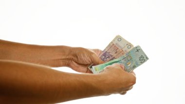 Beyaz zloti banknotlarını tutan eller. Ayrıntılı para birimlerini yakından gösteren tek kare.