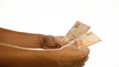 İzole edilmiş beyaz bir arkaplan üzerinde el ele tutuşan Türk lirası..