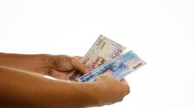 Çin yuan banknotlarını tutan eller beyaz bir arkaplanda izole edilmiş, Çin 'de para değişimi ya da finansal işlemleri gösteriyor