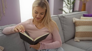 Kadınlar kitap okurken, şık oturma odasındaki rahat koltukta Pastel dekorla, rahat tavırlarını ve modern iç dünyasını ön plana çıkarıyor..