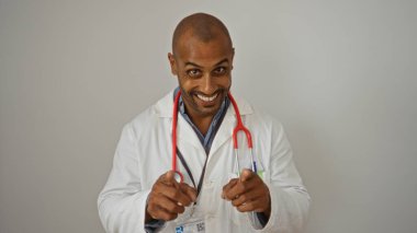 Smiling doctor with stethoscope wearing white coat pointing fingers at the camera over isolated white background clipart