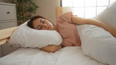 Genç, güzel, esmer saçlı, ispanyol bir kadın bir evin sıcak iç odasının içinde yatakta uyuyor..