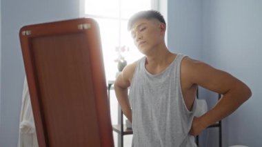 Kaplıca odasında kendini aynada inceleyen genç bir adam. Gri bir atlet giyiyor. Etrafı sakin bir sağlık merkeziyle çevrili..