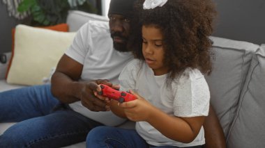 Baba ve kızı evlerinde oturup video oyunu oynuyorlar sıcak bir oturma odası ortamında sıcak aile sevgisiyle..