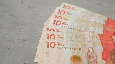 On bin pezoluk Kolombiya banknotları, detaylı tasarım ve parasal değerlerini gözler önüne seren beton bir yüzeye serilmişti.